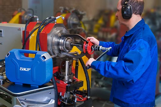 Image of an engineer using a hydraulic bearing puller to remove a bearing