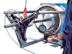 An engineer uses a heavy-duty hydraulically assisted bearing puller to remove a large spherical roller bearing