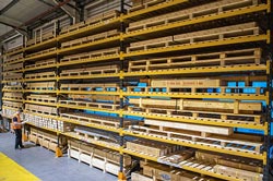 A warehouse operative at the side of guide rails on pallet racking shows the sheer scale of products carried in stock.