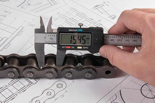 Image of someone measuring a chain roller using a vernier calliper