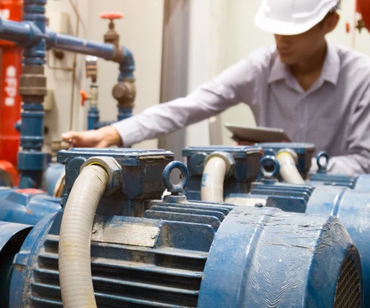 Man inspecting a large industrial pump