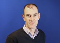 Image of product manager, Garry Haines stood in front of a dark blue background